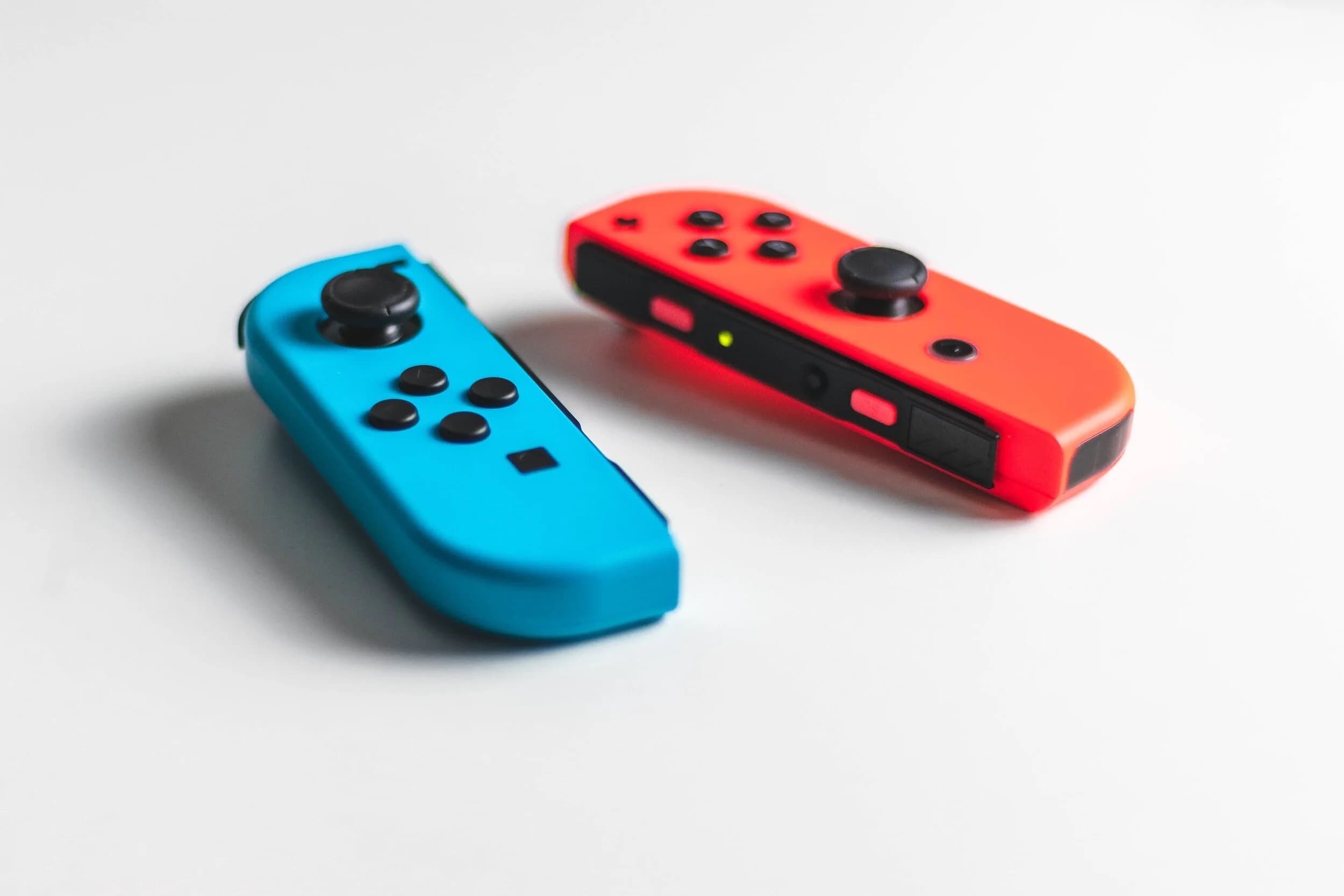 Neon blue and red Nintendo Switch Joy-Cons on a clean surface