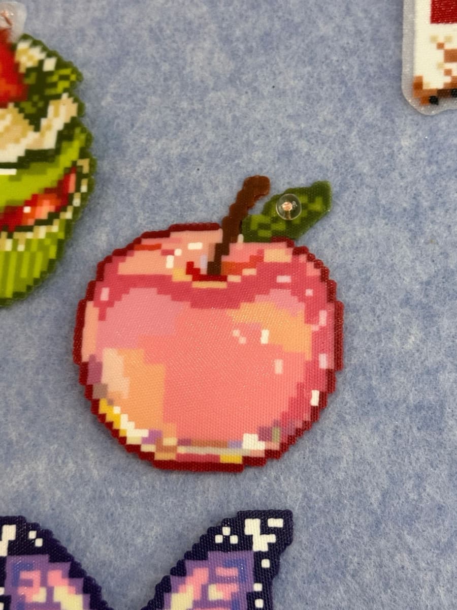 Pixel-art apple charm fused from pink and red mini beads, with stem and leaf